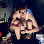19433059 – a teenager plays video console games on his television