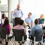 31047575 – businessman addressing multi-cultural office staff meeting