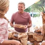 42131630 – family buying bread from bakery stall at farmers market