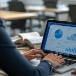 woman with business data on laptop screen