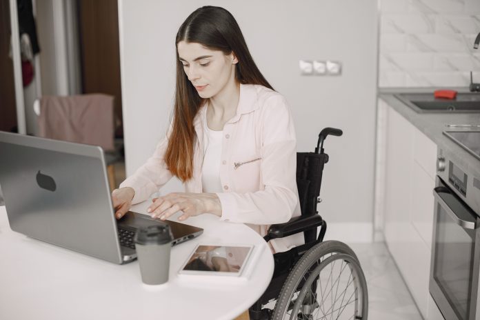 disabled woman in wheelchair using laptop disabled woman in wheelchair using laptop